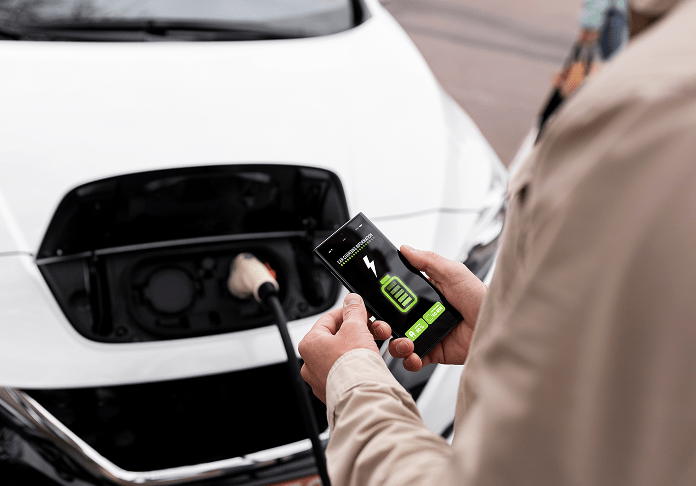 Person Monitoring Electric Car Charging with Battery Level Indicator Display