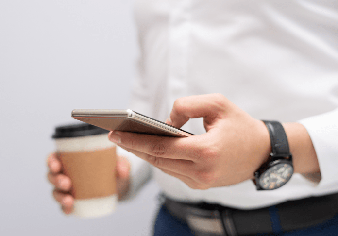 Man in White Shirt Holding Smartphone and Coffee Cup with Watch